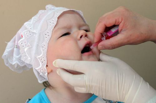 Ребенку капают вакцину от полиомиелита