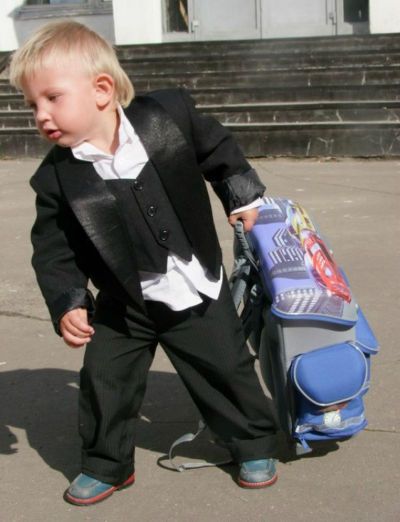 Ребенок тащит тяжелый рюкзак