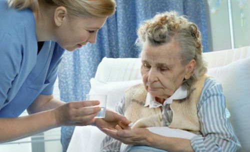 Пожилая пациентка принимает лекарство